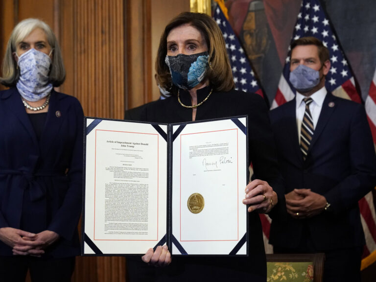 House Speaker Nancy Pelosi of Calif., displays the signed article of impeachment against President Donald Trump