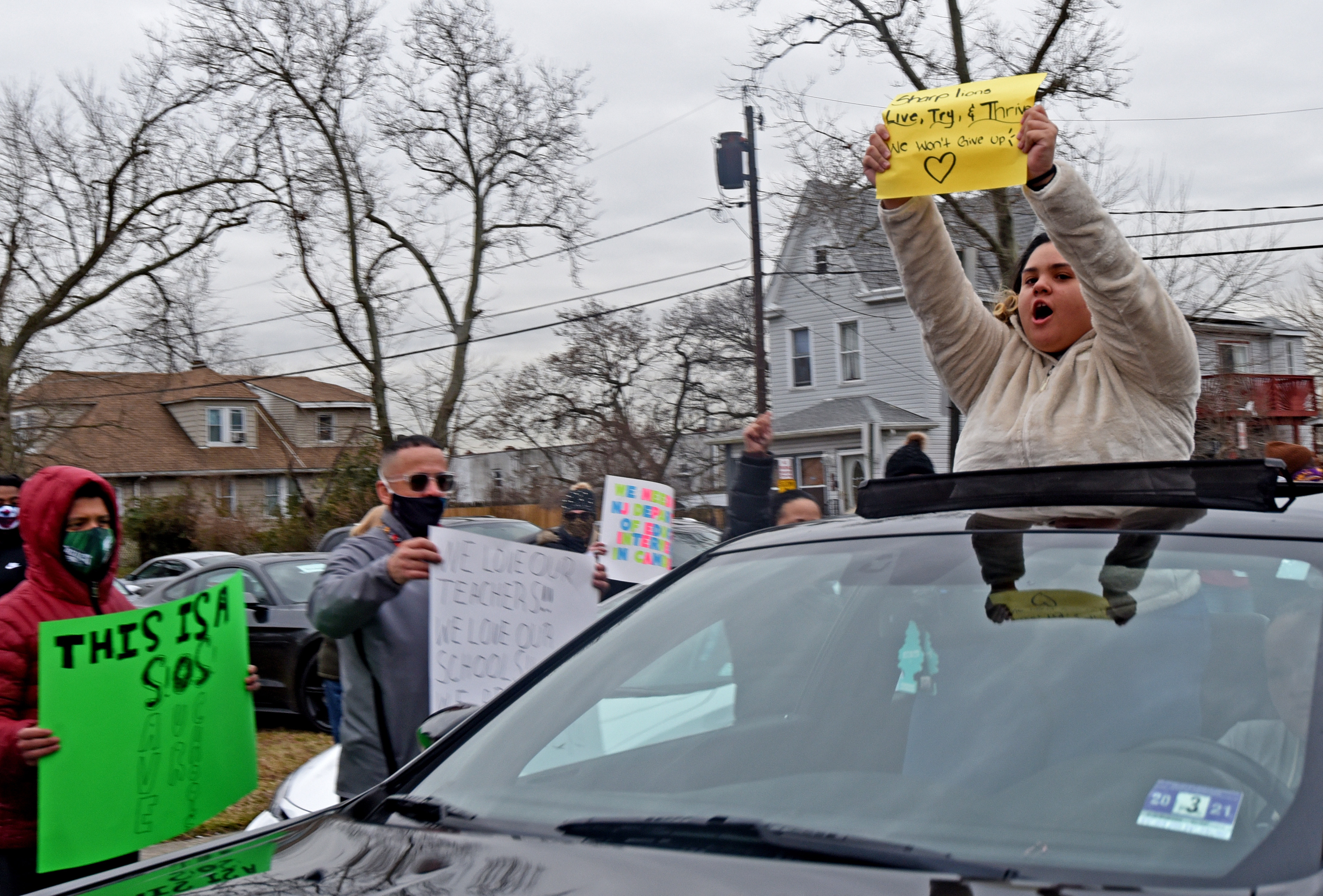 Taina Alicea, 17, protests from a car in front of Harry C. Sharp Elementary Schoo