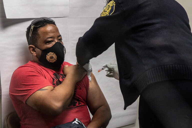Demetrio Olivieri, a firefighter with Philadelphia’s Ladder 24, receives the first dose of the Moderna COVID-19 vaccine on Jan. 6, 2021 from Captain April Smallwood.