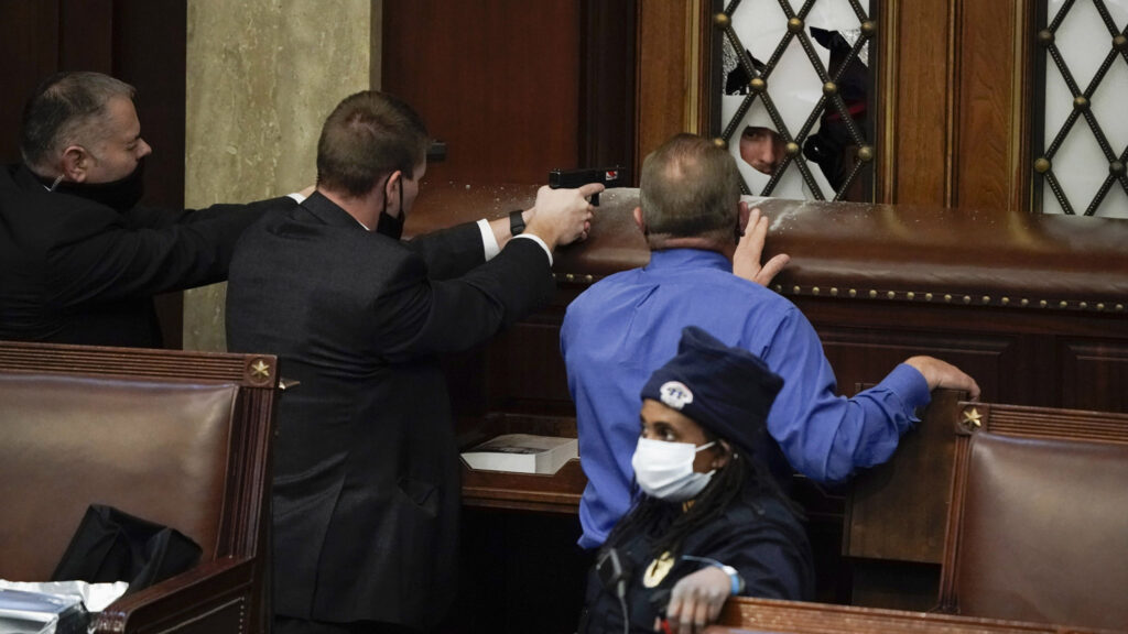 Police with guns drawn watch as protesters try to break into the House Chamber at the U.S. Capitol on Wednesday, Jan. 6, 2021, in Washington. (AP Photo/J. Scott Applewhite)