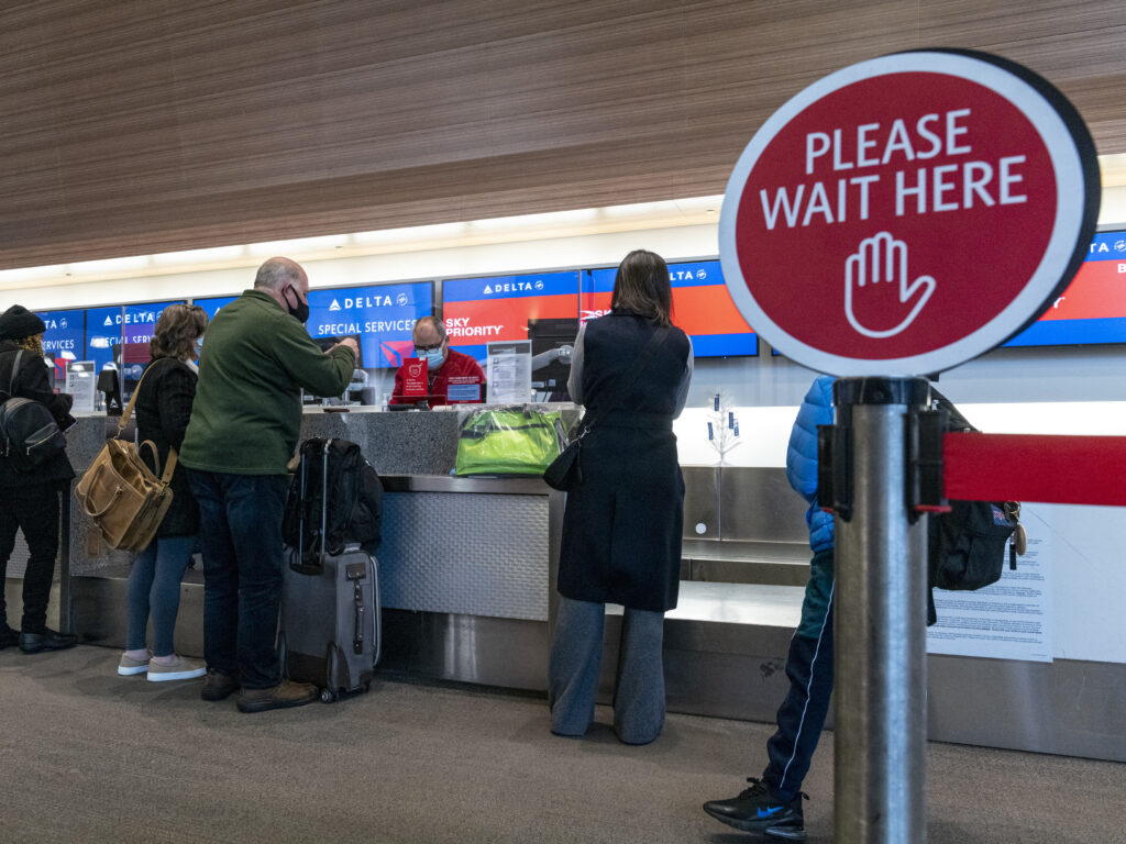 President Biden is expected to sign off on new travel restrictions on non-U.S. travelers from South Africa, Brazil, the United Kingdom, Ireland and 26 countries in Europe. Travelers wearing protective masks check-in at the Delta Air Lines Inc. check-in counter