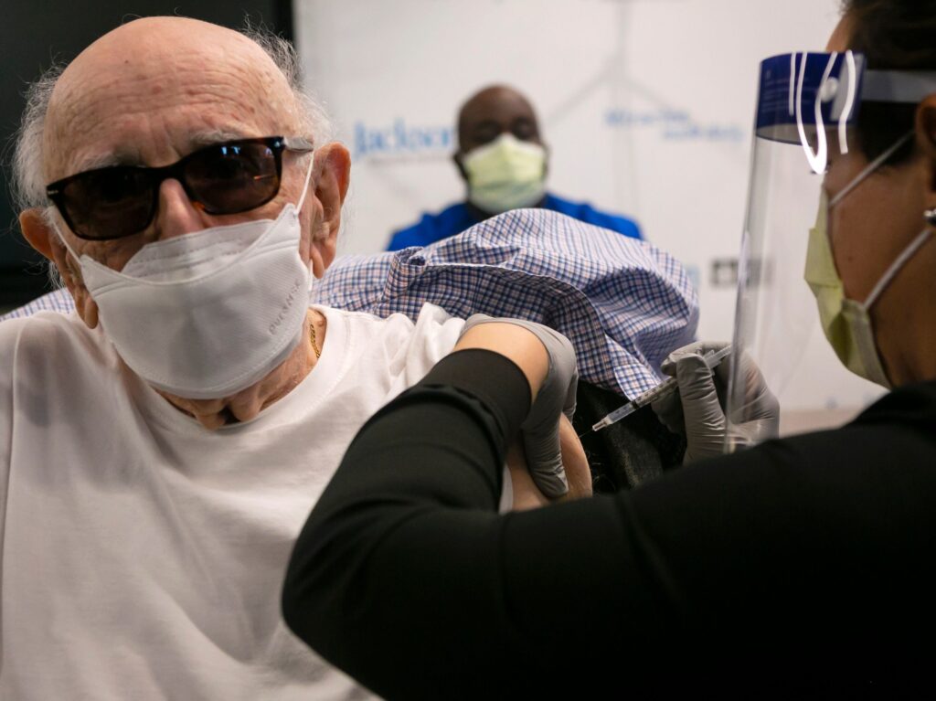 Norman Einspruch, 88, a cardiology patient at Jackson Memorial Hospital in Miami, Fla., receives his first dose of the Pfizer-BioNtech COVID-19 vaccine Dec. 30. Norman Einspruch, 88, a cardiology patient at Jackson Memorial Hospital in Miami, Fla., receives his first dose of the Pfizer-BioNtech COVID-19 vaccine