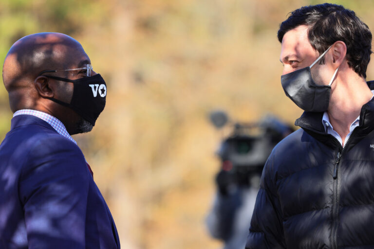 Georgia Sens.-elect Rev. Raphael Warnock (left) and Jon Ossoff before a campaign stop on Jan. 4. While the pair ran as a ticket, Warnock garnered nearly 20,000 more votes, in part due to many conservative voters' concerns about Warnock's GOP opponent, Sen. Kelly Loeffler.