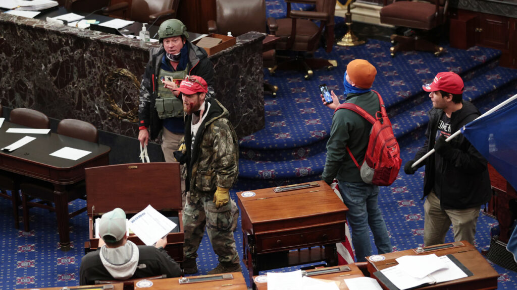Larry Rendall Brock Jr., an Air Force veteran, is seen inside the Senate Chamber wearing a military-style helmet and tactical vest during the rioting at the U.S. Capitol. Federal prosecutors have alleged that before the attack, Brock posted on Facebook about an impending “Second Civil War.” Larry Rendall Brock Jr., an Air Force veteran, is seen inside the Senate Chamber wearing a military-style helmet and tactical vest during the rioting at the U.S. Capitol. Federal prosecutors have alleged that before the attack, Brock posted on Facebook about an impending