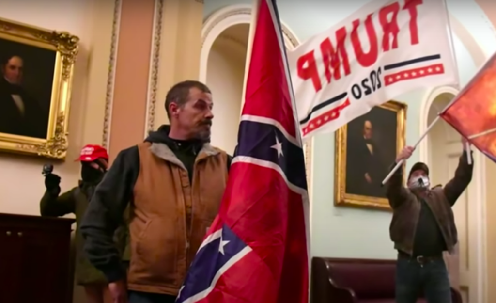 pro-trump_insurrection_capitol_confederate_flag_011421 Kevin Seefried carries a Confederate flag inside the U.S. Capitol