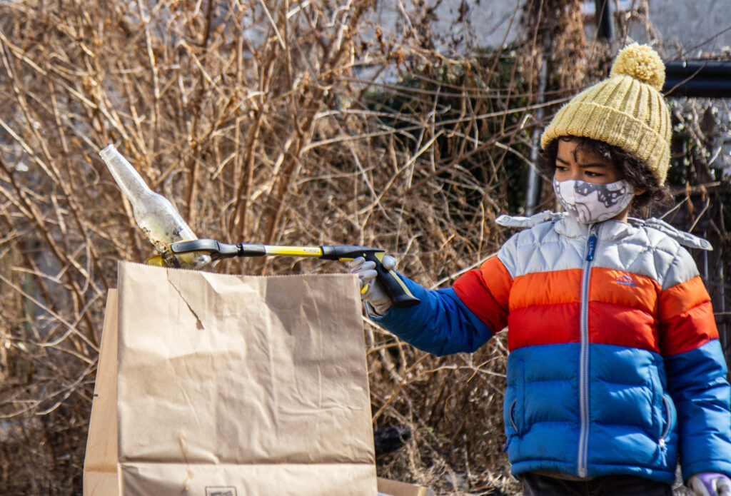 ya_fav_trashman_MLK_day_of_service_KP_011821_02 Eiji Mizukane places a glass bottle into a paper trash bag during a North Philly cleanup