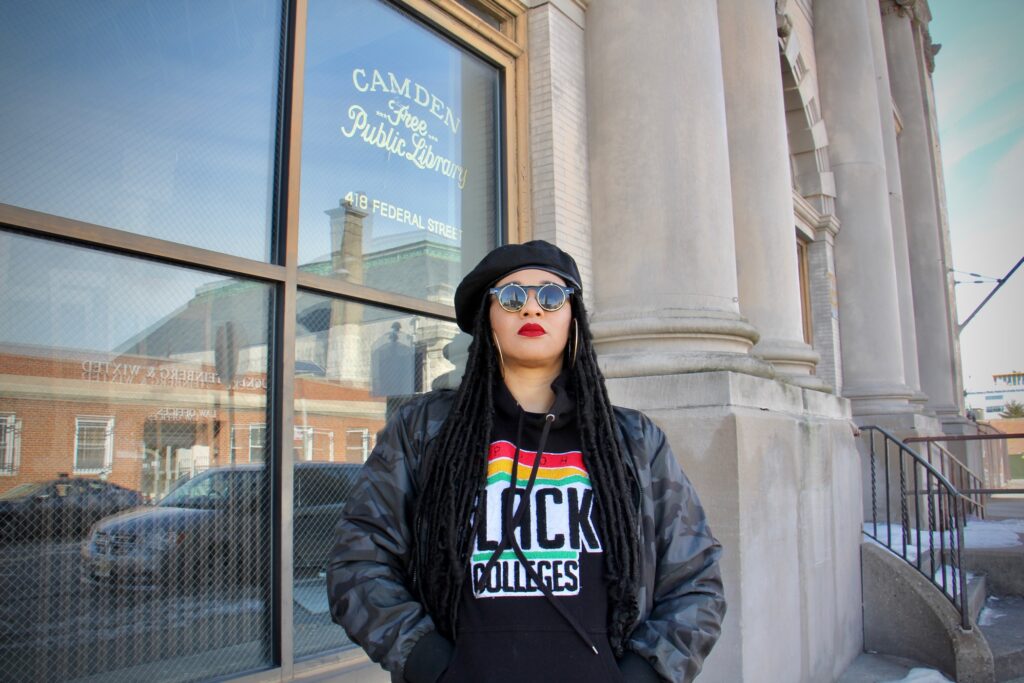 202 02 17-e lee-danielle jackson-camden nj old public library-hoodbrarian glasses Danielle Jackson, the 'Hoodbrarian,' stands outside the old Camden Public Library building on Federal Street, which has been abandoned since 2011. (Emma Lee/WHYY)