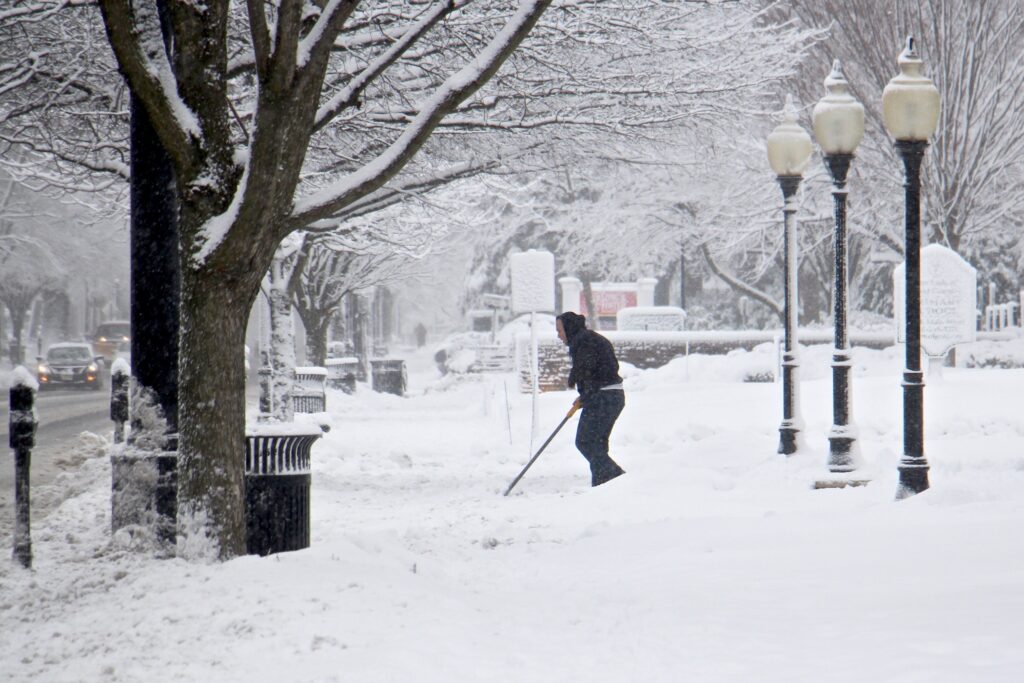 2021 02 02-e lee-moorestown nj-snow day shoveler A shoveler clears the walkway to Our Lady of Good Counsel Church