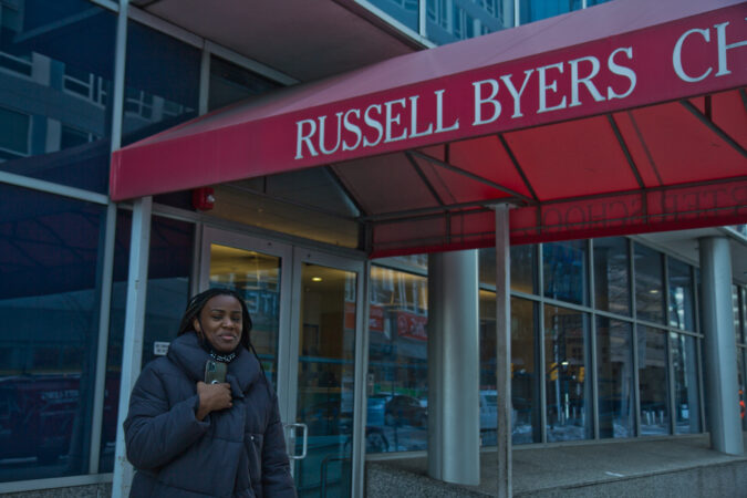 Sade Greenlee stands in front of Russell Byers Charter school