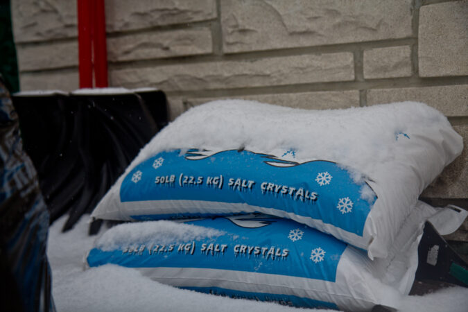 Bags of rock salt are piled on top of one another