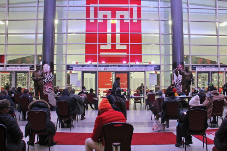 Philadelphians wait in the lobby of the Liacouras Center at Temple University to receive the Moderna COVID-19 vaccine.