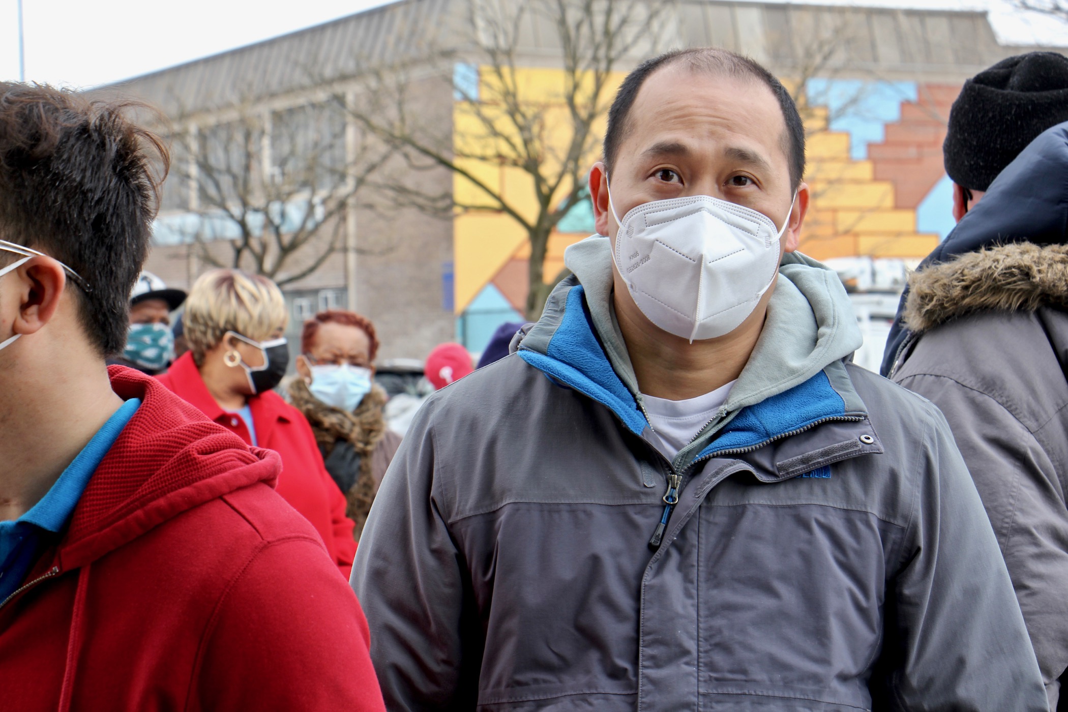 Chuong Doan waits in line to receive a COVID-19 vaccine