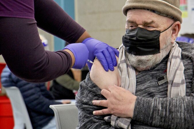 Francis Gayton, 70, receives his first COVID-19 vaccination