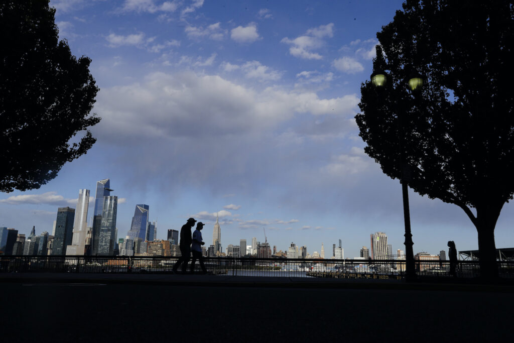 Virus Outbreak New York Pedestrians walk in Maxwell Place Park in view of midtown Mahattan Thursday, May 7, 2020, in Hoboken, N.J. (AP Photo/Frank Franklin II)