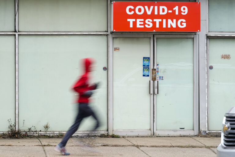 Person running in front of a covid testing site.