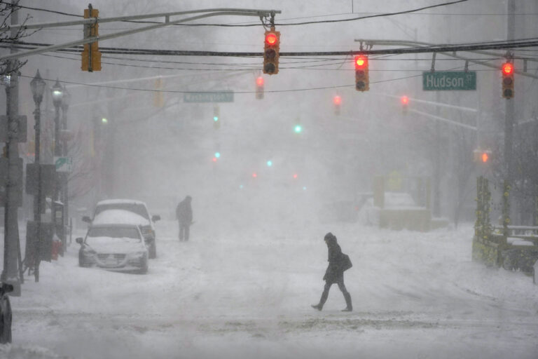 A few pedestrians are seen walking in the heavy snow and wind in Hoboken, N.J., Monday, Feb. 1, 2021. (AP Photo/Seth Wenig)