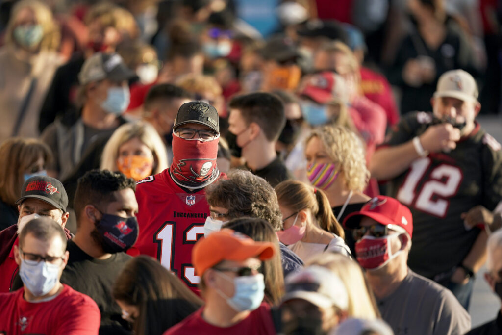 People wait in line for an exhibit at the NFL Experience Thursday, Feb. 4, 2021, in Tampa, Fla. The city is hosting Sunday’s Super Bowl football game between the Tampa Bay Buccaneers and the Kansas City Chiefs. (AP Photo/Charlie Riedel)