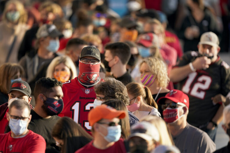People wait in line for an exhibit at the NFL Experience Thursday, Feb. 4, 2021, in Tampa, Fla. The city is hosting Sunday’s Super Bowl football game between the Tampa Bay Buccaneers and the Kansas City Chiefs. (AP Photo/Charlie Riedel)