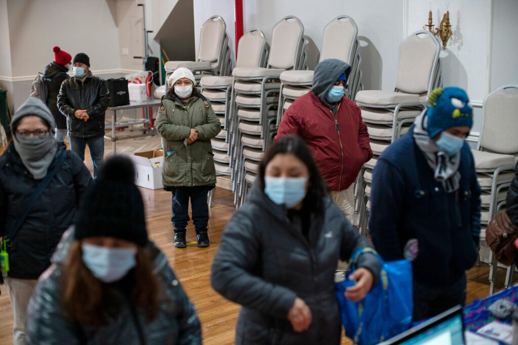 AP21046012239811 People wait to fill out forms at the community center Mixteca to receive food and get information about the COVID-19 vaccination during the coronavirus pandemic, Saturday, Feb. 13, 2021, in Brooklyn. (AP Photo/Eduardo Munoz Alvarez)