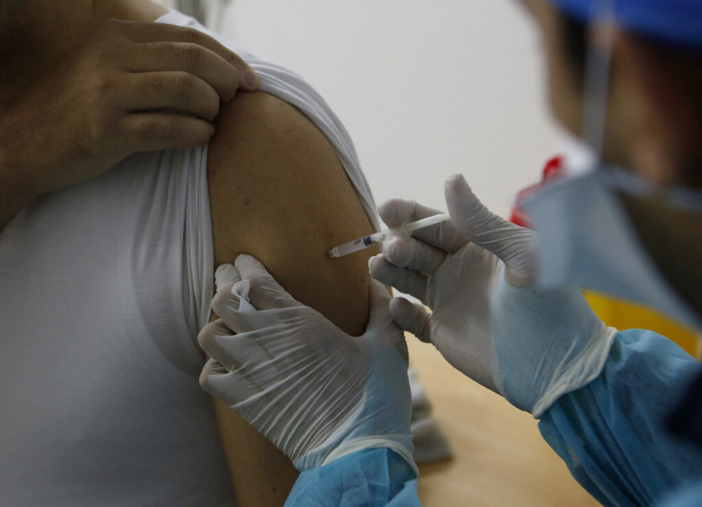 Virus Outbreak Covax Explainer A nurse administers the COVID-19 vaccine to a health worker.