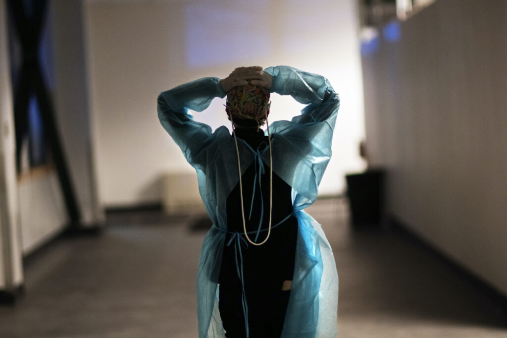 Virus Outbreak Half Million Dead Photo Gallery A nurse walks down a hallway with her arms in the air, clasping the back of her head