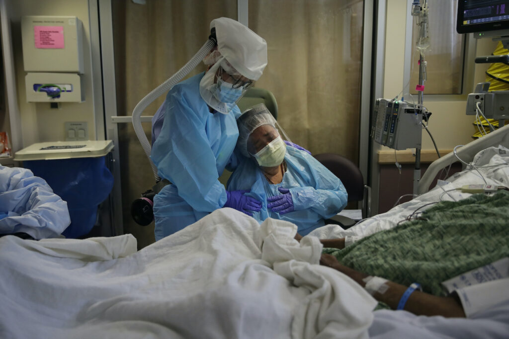 Michele Younkin, Romelia Navarro, Antonio Navarro Romelia Navarro, right, is comforted by nurse Michele Younkin, left, as she weeps while sitting at the bedside of her dying husband