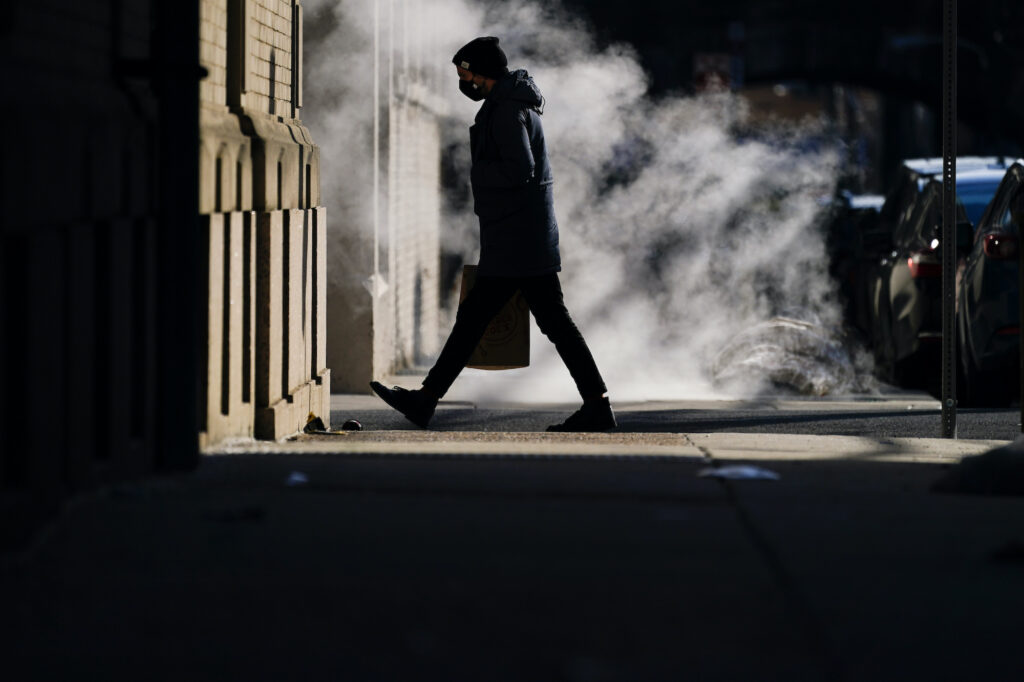 Virus Outbreak Pennsylvania A person wearing a face mask as a precaution against the coronavirus walks in Philadelphia