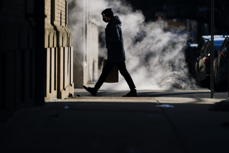 A person wearing a face mask as a precaution against the coronavirus walks in Philadelphia