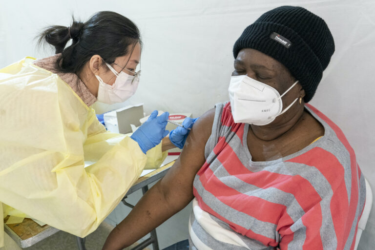 Registered Nurse Shyun Lin, left, gives Alda Maxis, 70, the first dose of the COVID-19 vaccine at a pop-up vaccination site