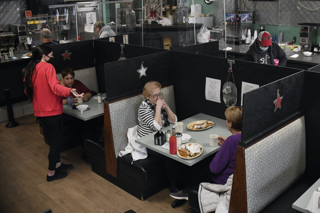 Virus Outbreak Connecticut A server talks with a customer seated at Rodd's Restaurant