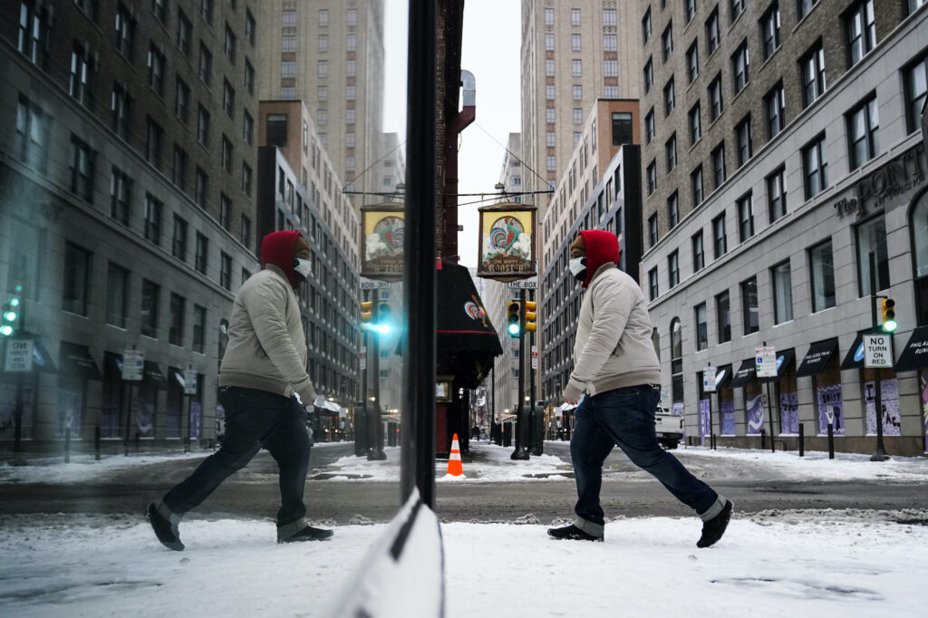 Winter Weather Pennsylvania A person, reflected in a window while wearing a face mask as a precaution against the coronavirus, walks during a winter storm in Philadelphia