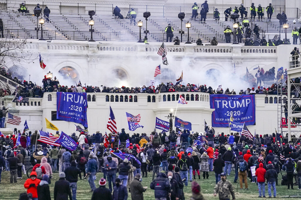 Capitol Breach Arrests Protesters holding Trump 2020 flags and signs storm the Capitol in Washington D.C.