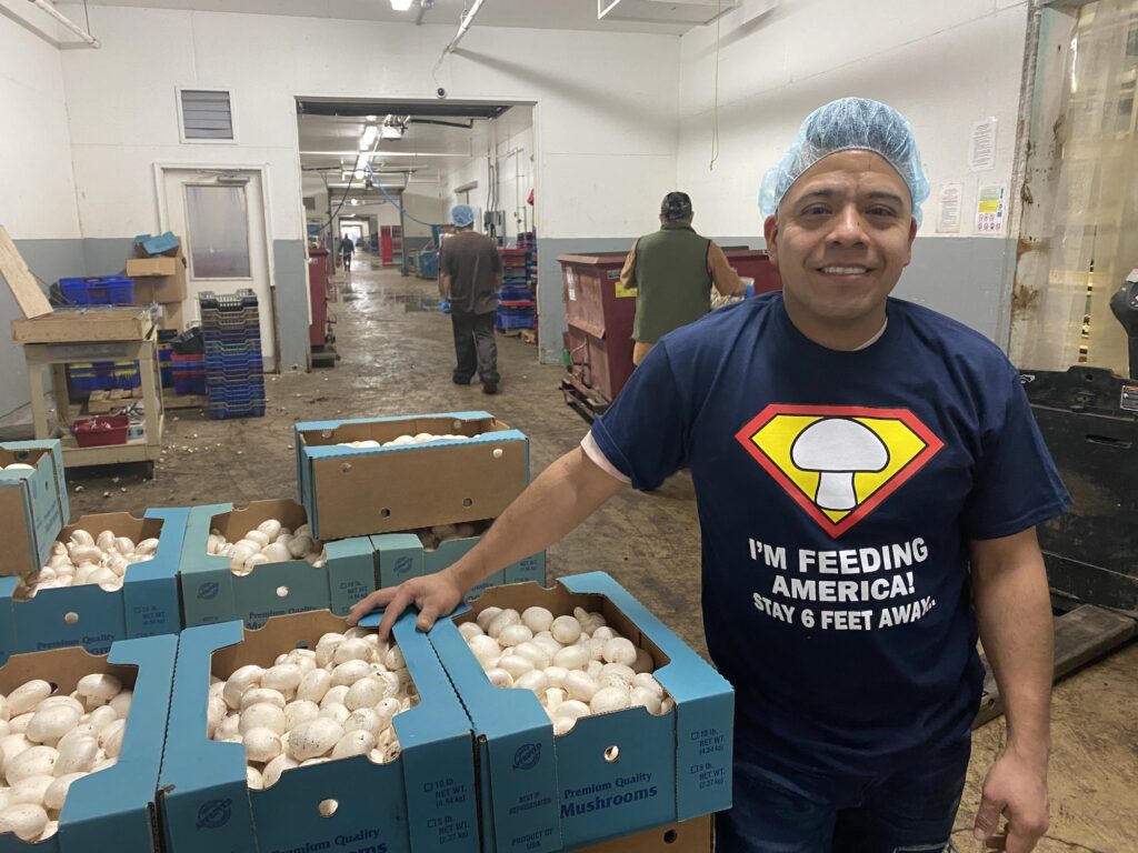 alejandro_romero_mushroom_farm_021421 Alejandro Romero smiles inside a farm building at Pietro Industries