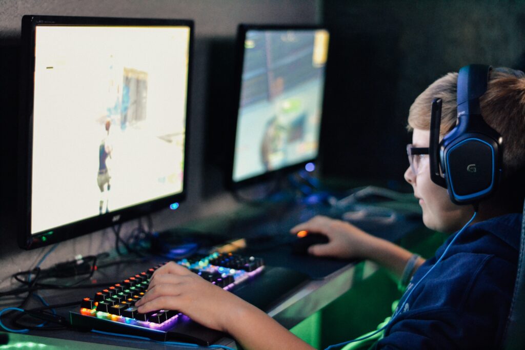 alex-haney-xWkRYoSf8_c-unsplash A young person plays video games online