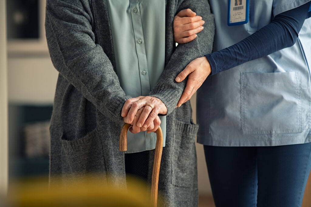 Close up hands of caregiver doctor helping old woman at clinic. Close up hands of caregiver doctor helping old woman at clinic.