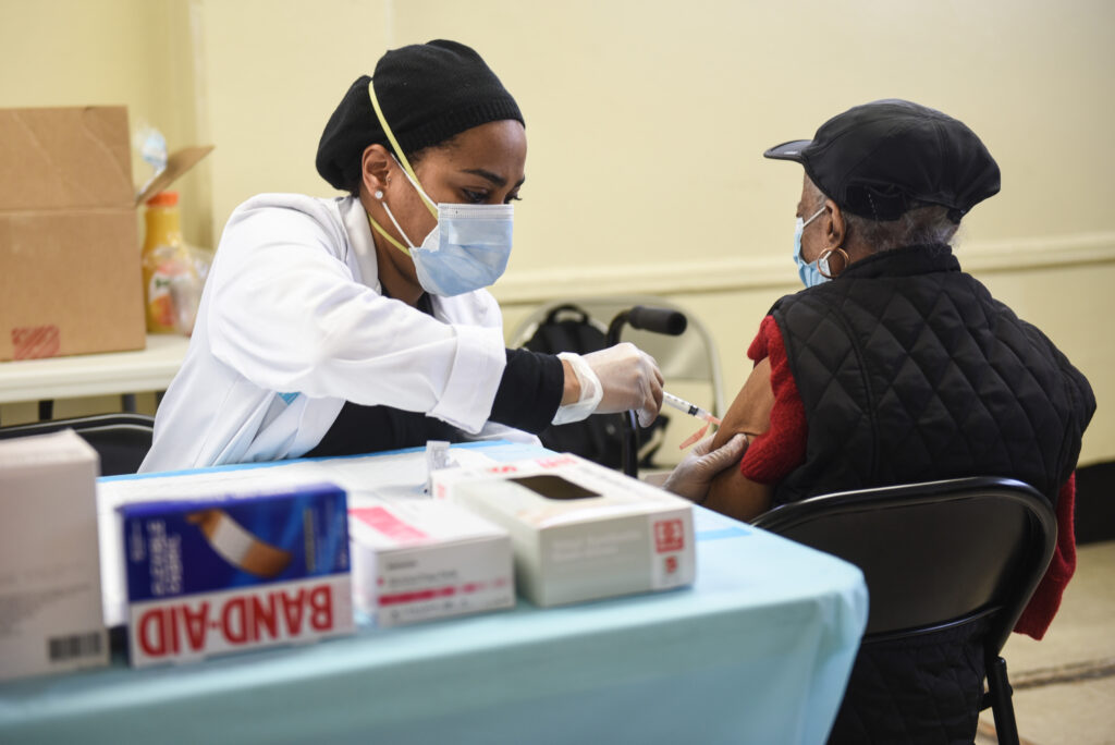 NYCHA vaccination site A person administers a COVID-19 vaccine