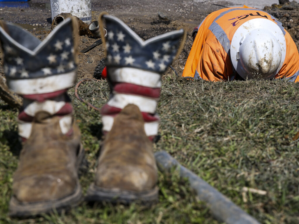 A worker fixes a water pipe in Galveston, Texas, on Feb. 19. The power is back on in much of the state, but the Lone Star State now faces the hefty cost of emerging from its devastating storms.