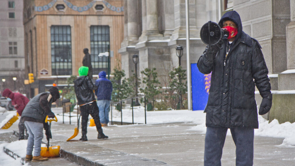 Jamal Johnson protests in the snow at City Hall