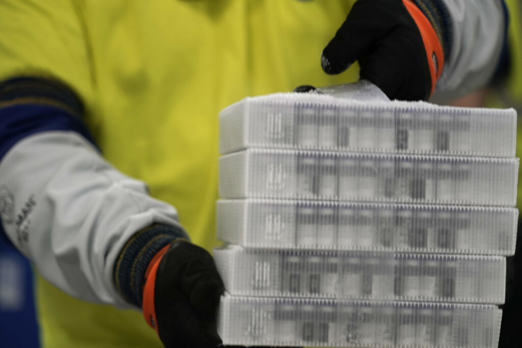 A worker carries boxes containing the Pfizer-BioNTech COVID-19 vaccine that were being prepared for shipment from a Pfizer facility in Portage, Mich., in December. A worker carries boxes containing the Pfizer-BioNTech COVID-19 vaccine that were being prepared for shipment from a Pfizer facility in Portage, Mich., in December. (Morry Gash/Pool/Getty Images)