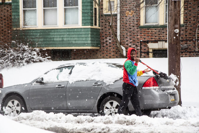 A Philadelphian clears off their car in Philadelphia’s Frankfort neighborhood.