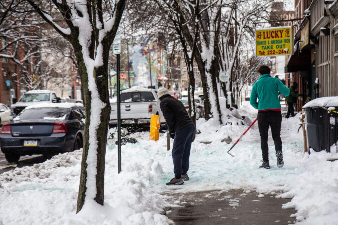 Residents clear the sidewalk in Belmont