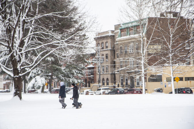 Residents walk in the snow at Norris Square Park in Kensington