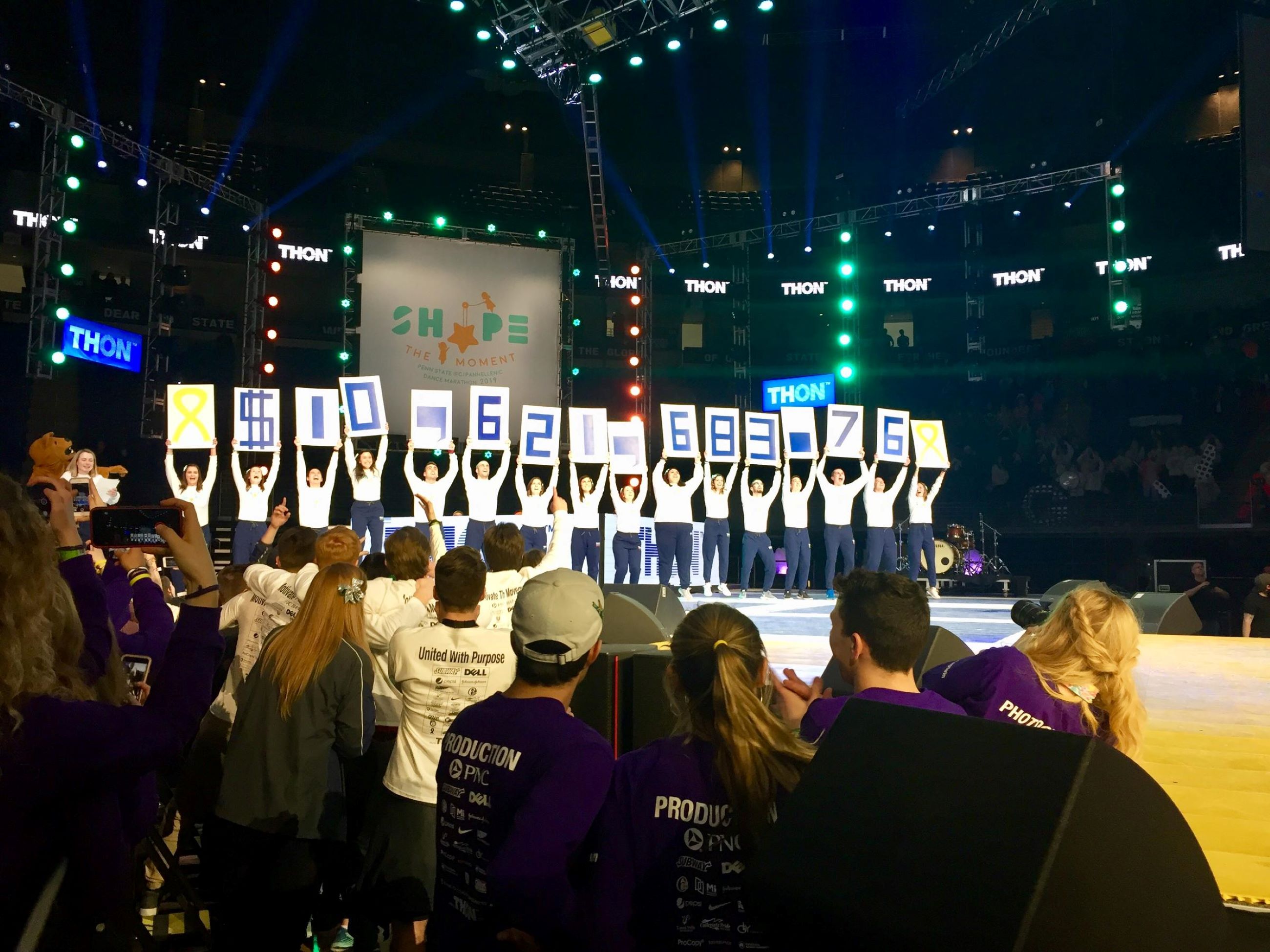 Penn State THON participants raise up signs indicating more than $10 million raised for pediatric cancer research in 2019.