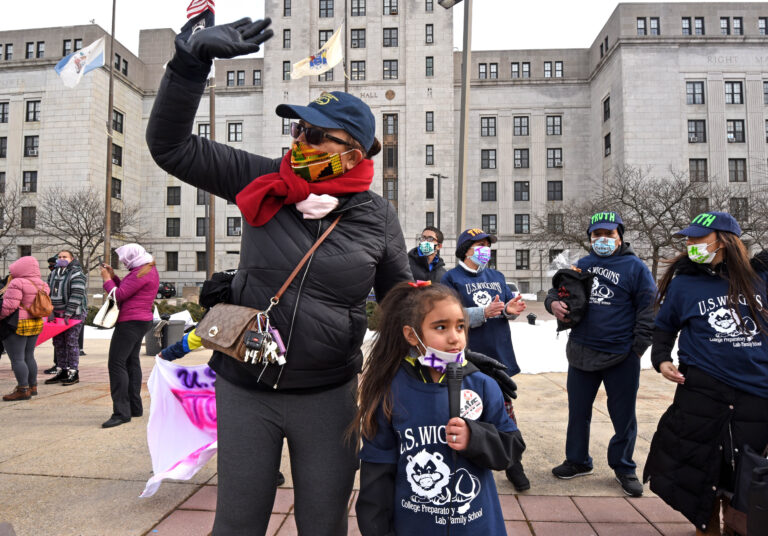 Ednalieze Figueroa, 5, who attends Wiggins School in Camden, protests the closure of her school on Fabruary 6, 2021 with an assist from activist Victoria Pellot.  (April Saul for WHYY)