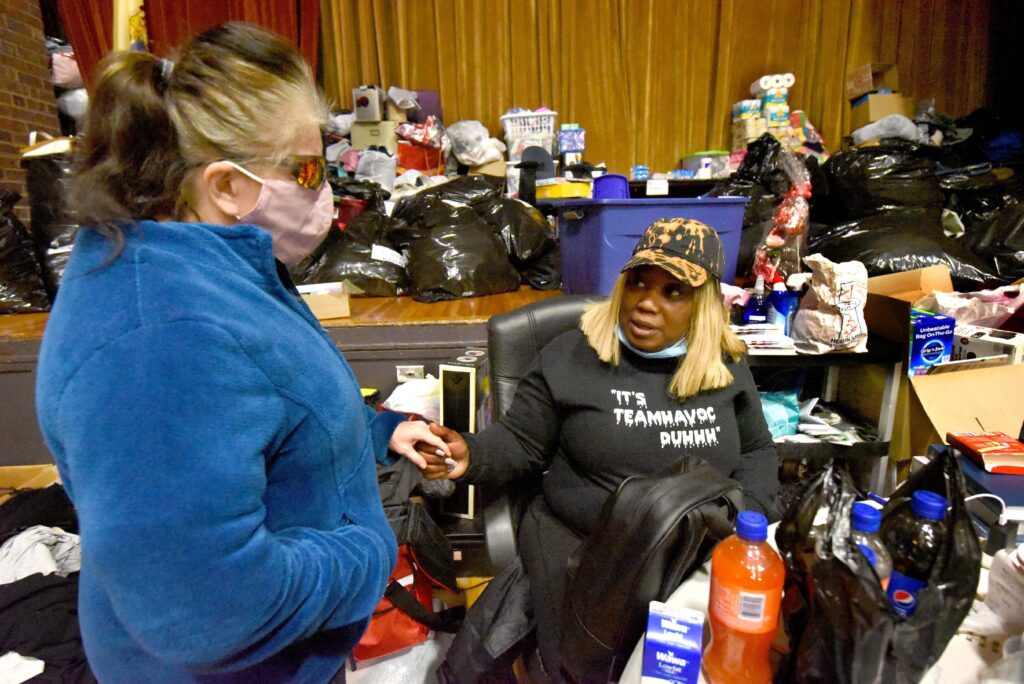 On March 5, 2021, at her warming center in the Yorkship Family School gym, Tawanda Jones, right, tries to convince a patron known as Sarah Ann to allow Jones to help her rent a room at a boarding house. Sarah Ann had told Jones that if there was nowhere else to go that night, she would sleep in Camden's Evergreen Cemetery.  (Photo by April Saul for WHYY)