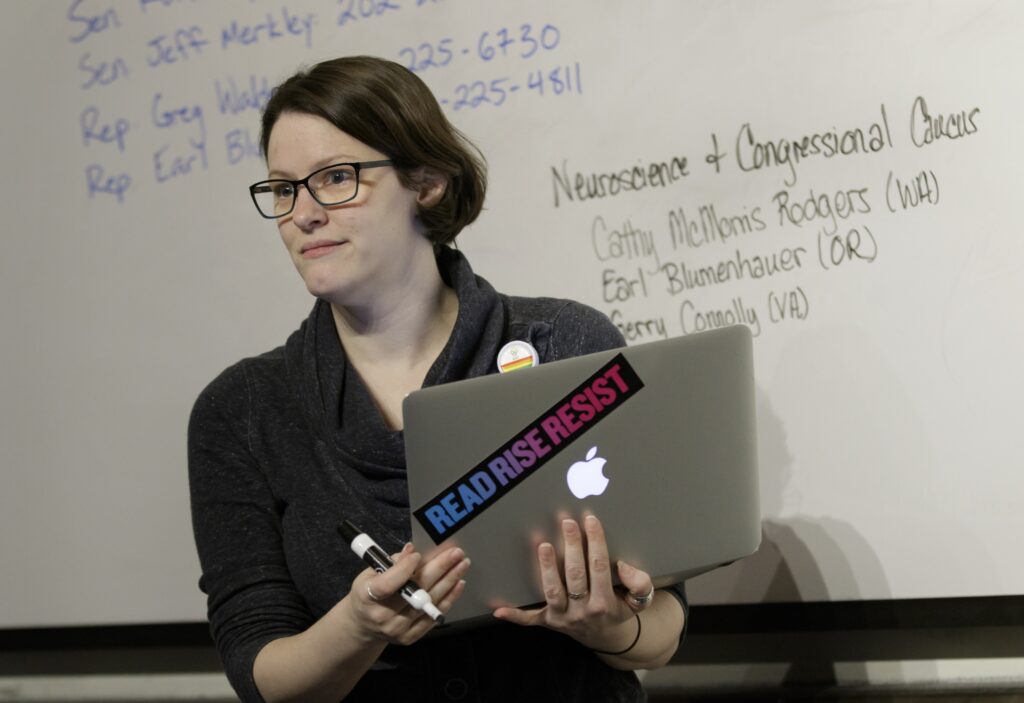 2017_1201_grad+student+tax+waiver_004_small OHSU School of Medicine student Mollie Marr stands in front of a whiteboard holding a laptop. She helps organize a letter-writing campaign for students to share personal stories about the impact of losing a proposed tax waiver for tuition for graduate students, December 1, 2017. Marr is pursuing her M.D. and her Ph.D. in behavioral neuroscience in the OHSU School of Medicine, and losing the tax waiver could mean dropping out of OHSU. (OHSU/Kristyna Wentz-Graff)