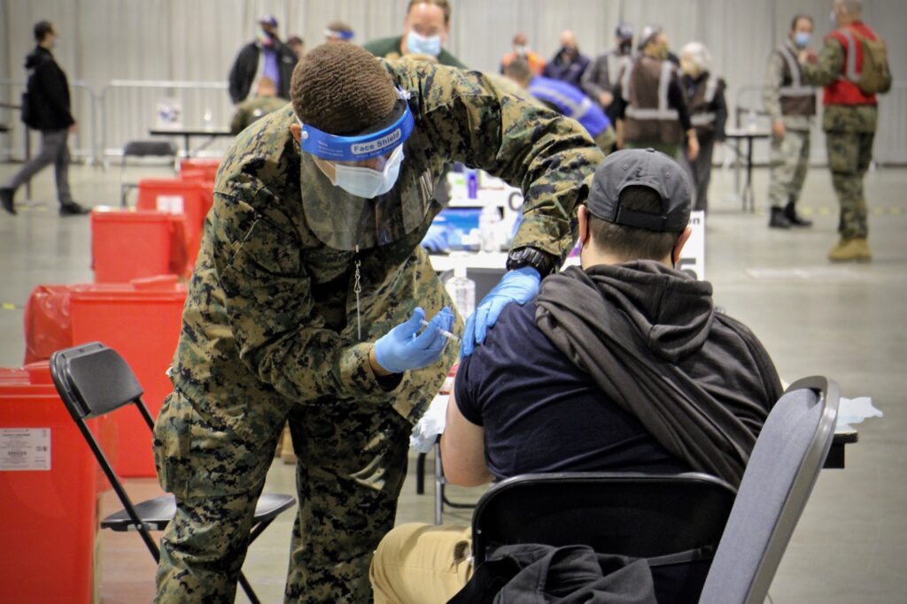 2021 03 02-e lee-philadelphia pennsylvania convention center-fema mass vaccine center shot A National Guard member vaccinates someone against COVID-19 at the Pennsylvania Convention Center