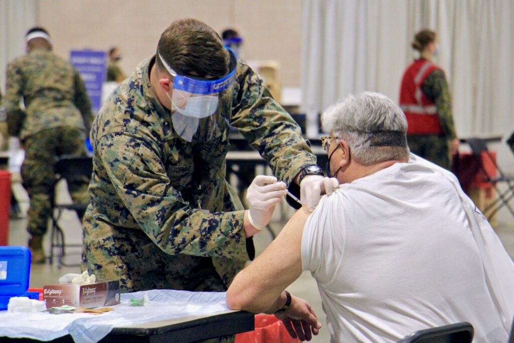 2021 03 02-e lee-philadelphia pennsylvania convention center-fema mass vaccine center shot 2 A National Guard member vaccinates someone against COVID-19 at the Pennsylvania Convention Center