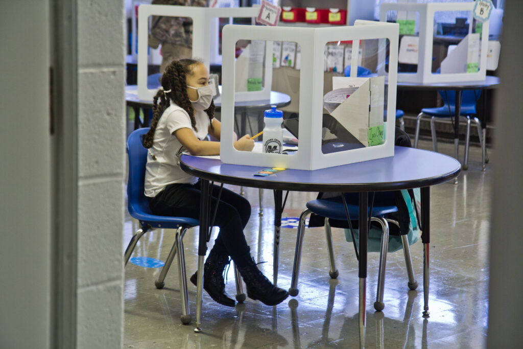 2021 03 03 k paynter mastery charter john wister returns_-6 A student, wearing a face mask, sits at an isolated desk at school