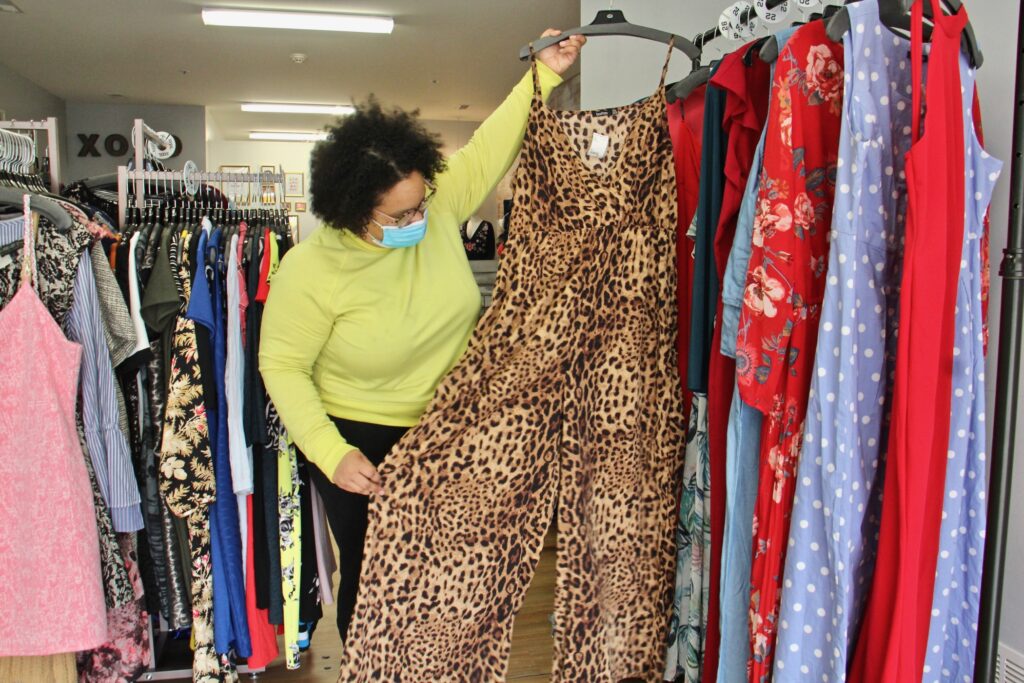 Adrienne Ray holds up a body suit inside Curve Conscious